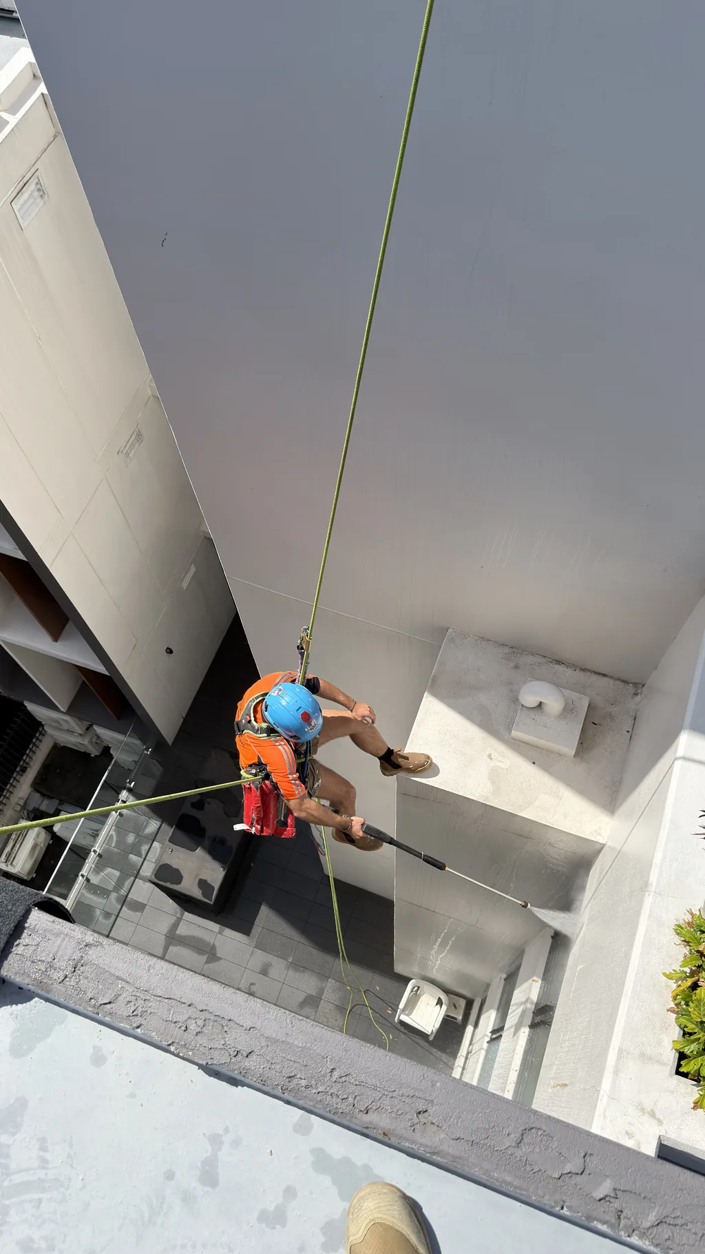 Rope access technician in a building's inner courtyard