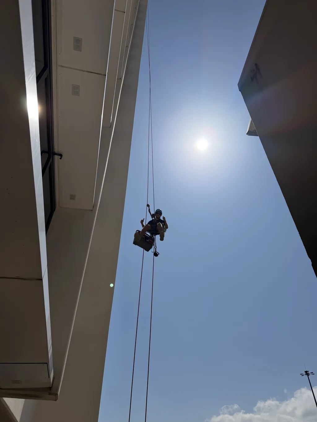 Rope access technician on the facade of a modern building