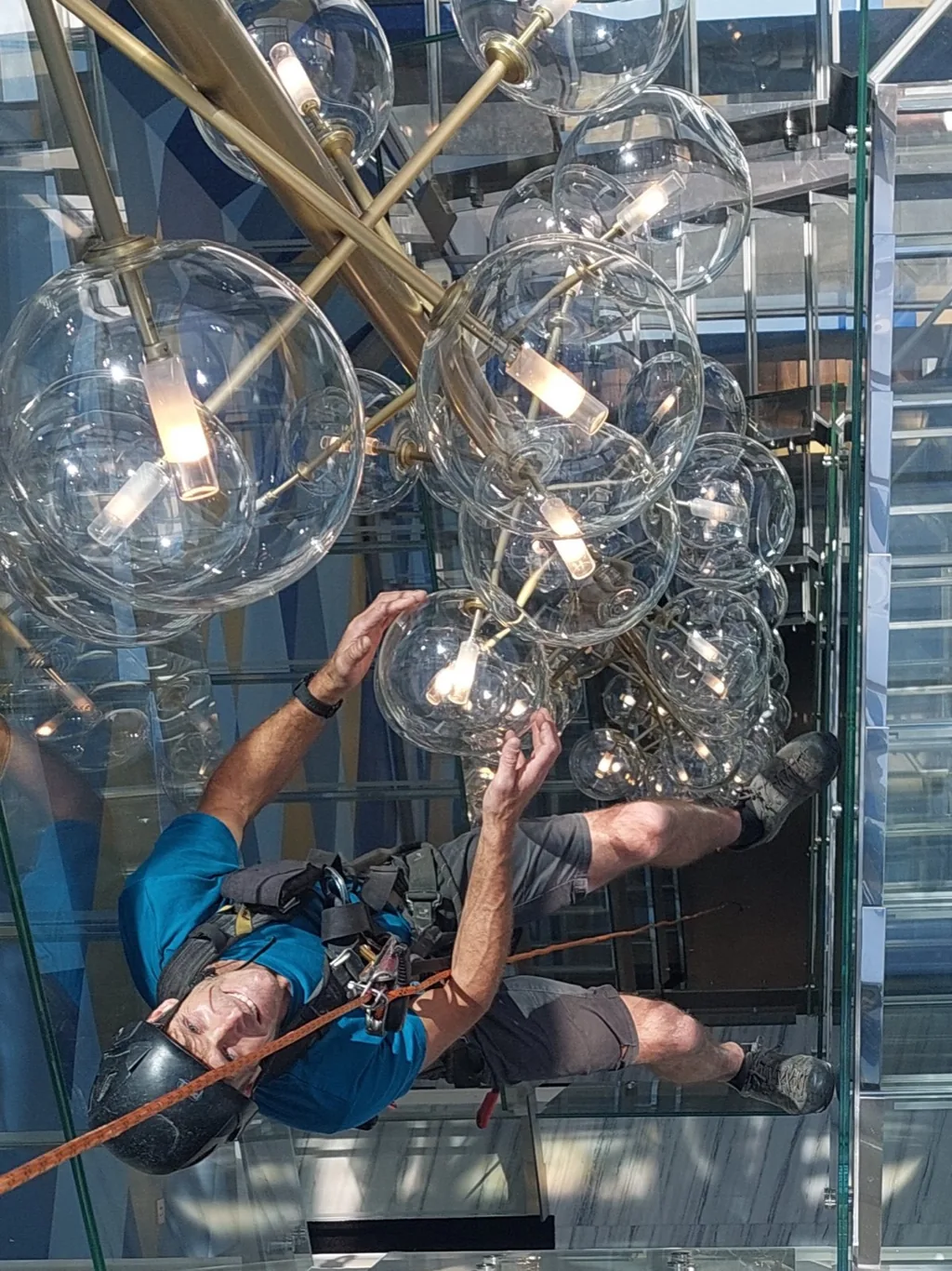 Rope access technician inside a chandelier in an atrium