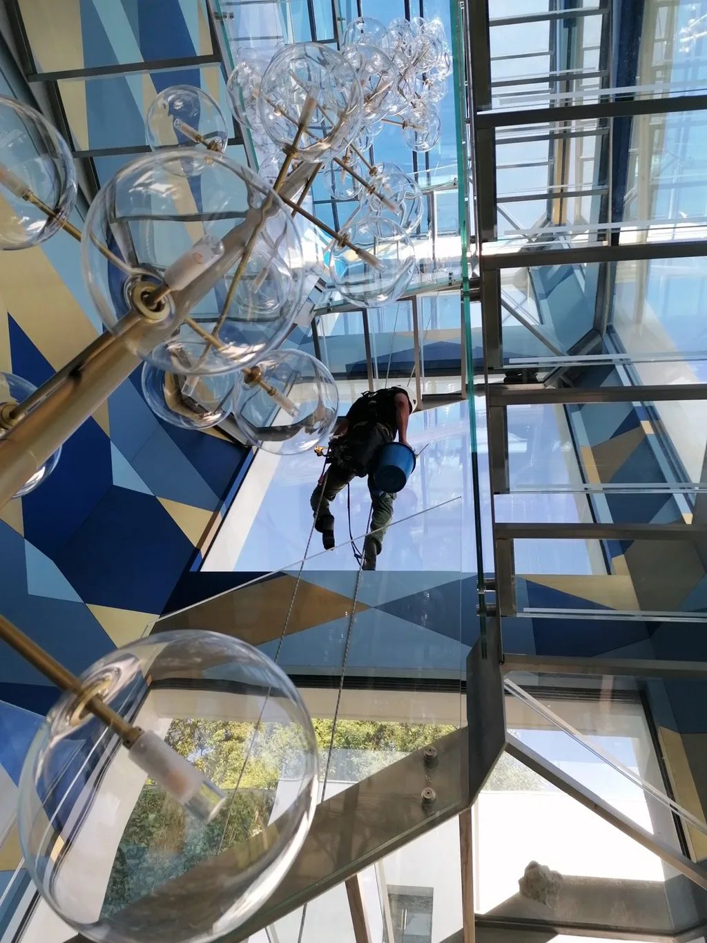 Rope access technician changing the bulbs of a light fitting at height