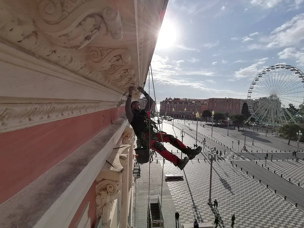 Rope access technician renovating a cornice, Place Masséna, Nice