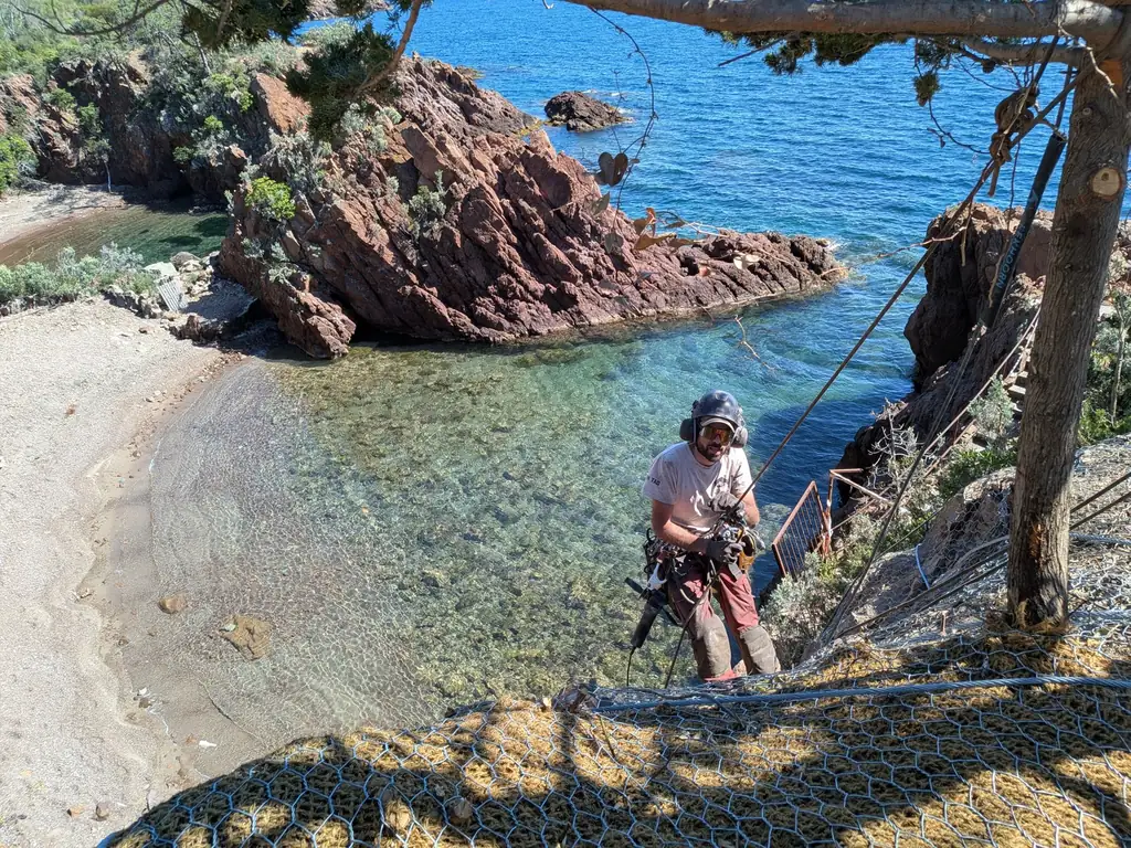 Rope access technician above a cove