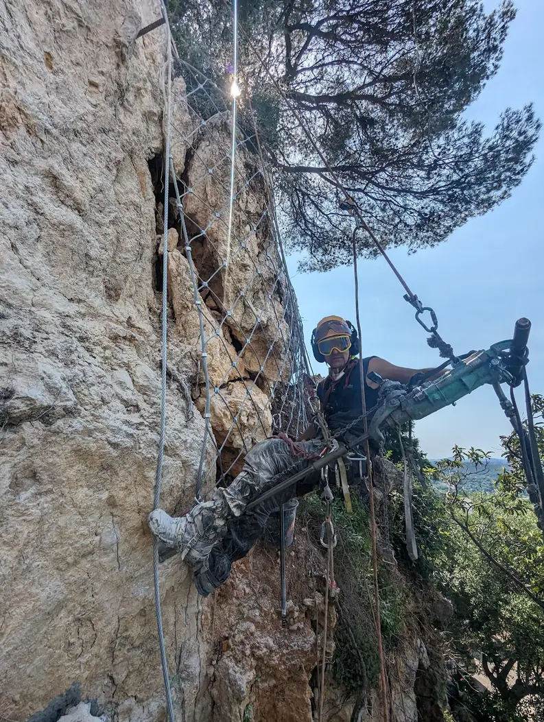 Drilling and installation of a rockfall net