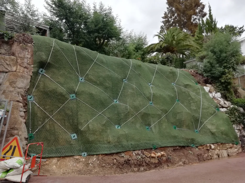 Embankment covered with geotextile and cables