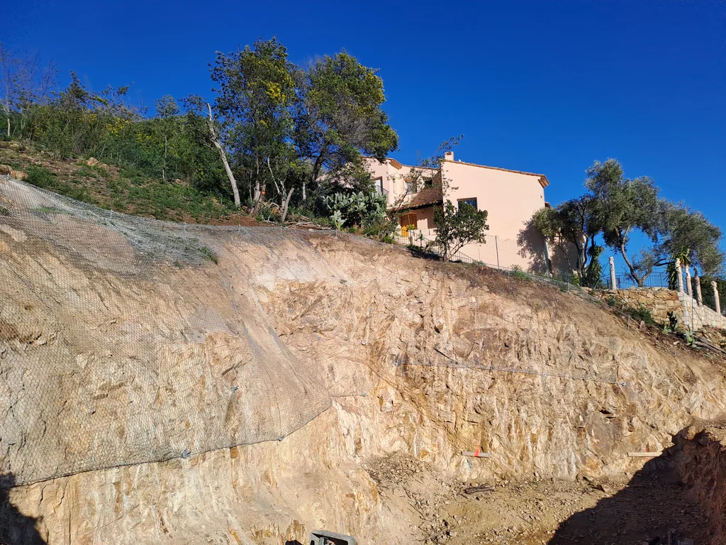 Scaled rocky embankment below a house